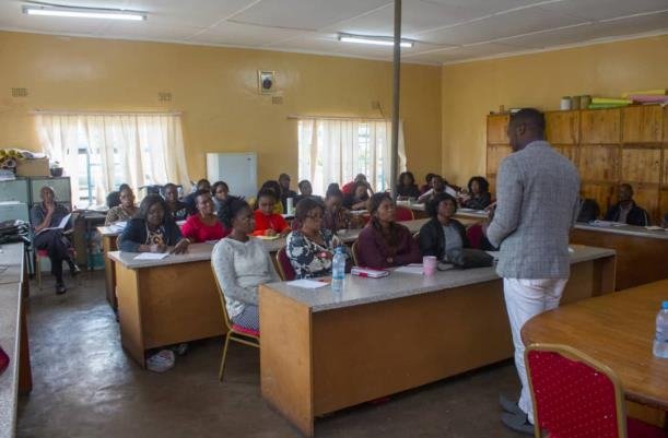 Teachers seated at desks in a classroom during an MCUSzambia training workshop